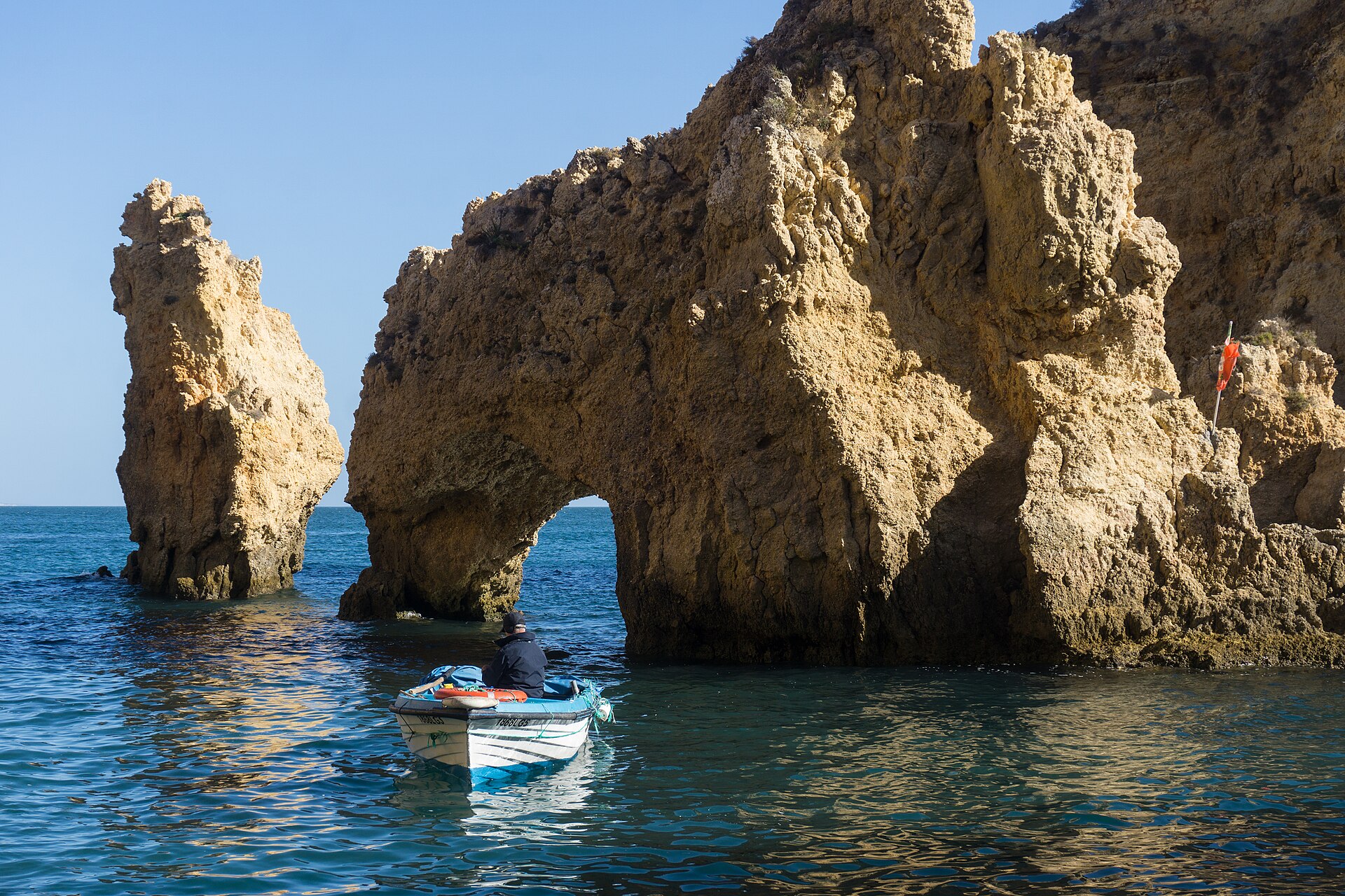 Klippvalv och båt vid Ponta da Piedade i Lagos